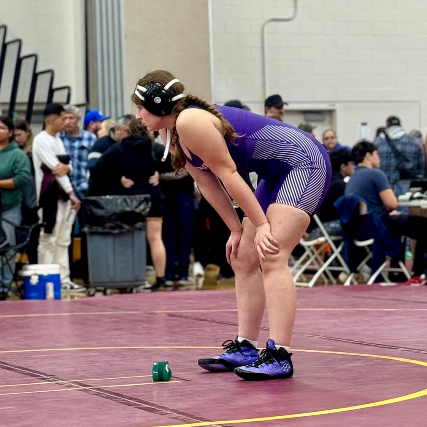 student resting with hands on knees between wrestling matches